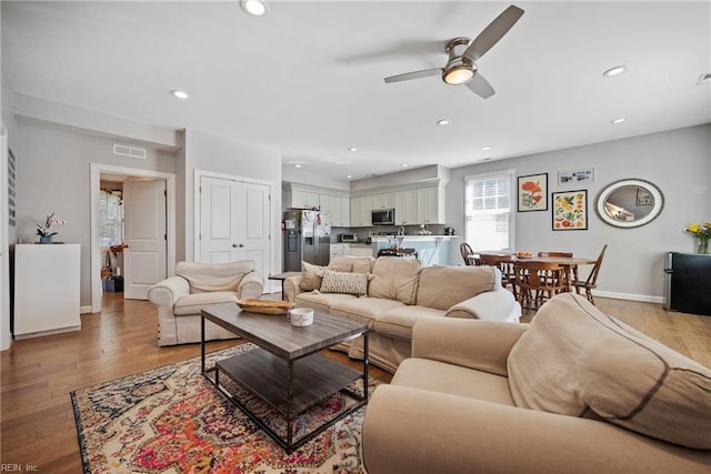 living area featuring recessed lighting, baseboards, ceiling fan, and wood finished floors