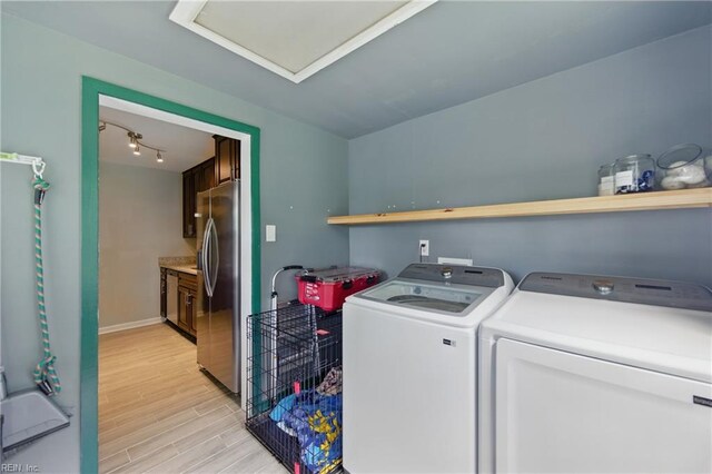 washroom featuring light wood-style floors, baseboards, laundry area, and washer and dryer
