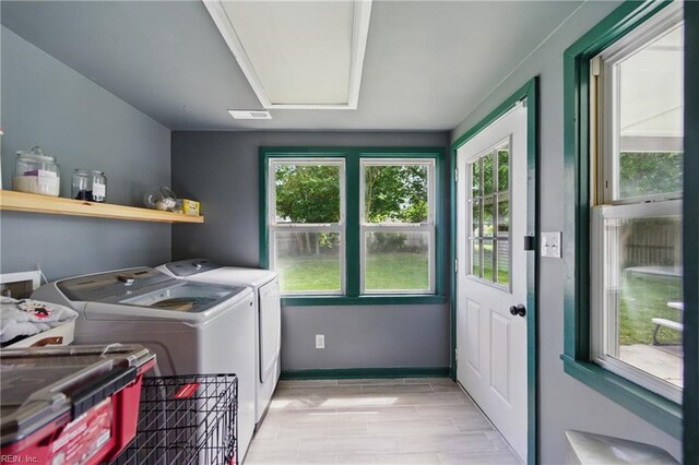 clothes washing area with washing machine and clothes dryer, laundry area, visible vents, and plenty of natural light