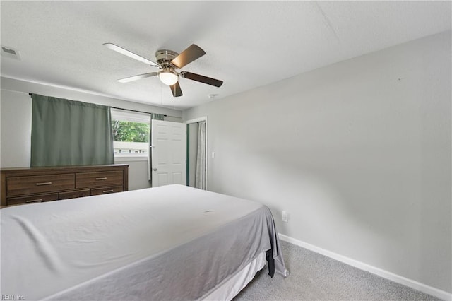 carpeted bedroom featuring baseboards, a ceiling fan, and visible vents