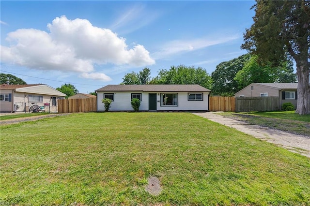 ranch-style house featuring fence and a front lawn