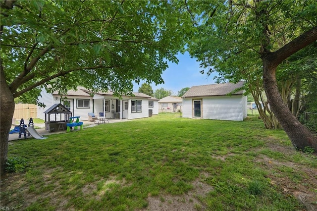back of property with a yard, a patio, and fence