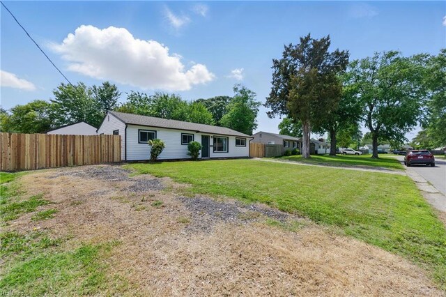 ranch-style home featuring fence and a front yard
