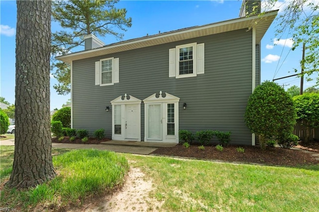 view of front of property with a chimney and a front yard