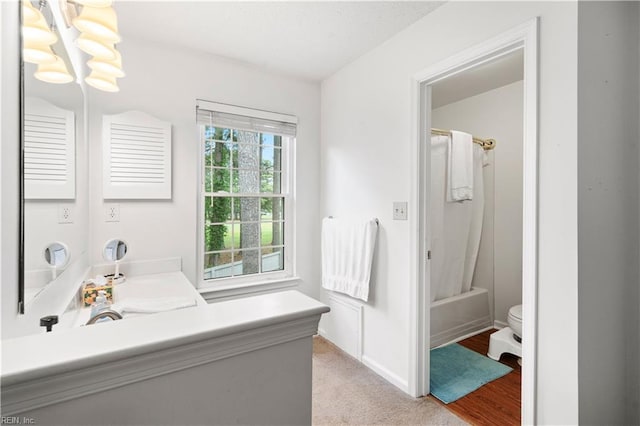 full bath featuring vanity, toilet, shower / tub combo with curtain, and baseboards