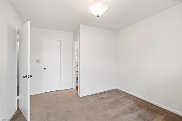 unfurnished bedroom featuring carpet and baseboards