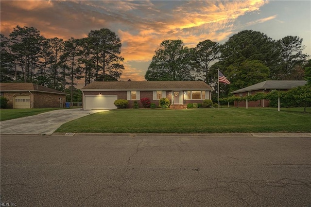 ranch-style house featuring an attached garage, driveway, and a front yard