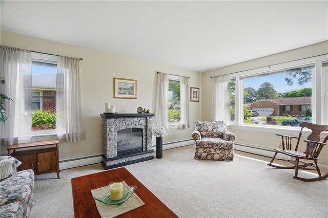 living room featuring carpet floors, a baseboard heating unit, and a stone fireplace