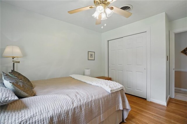 bedroom with ceiling fan, visible vents, baseboards, a closet, and light wood-style flooring