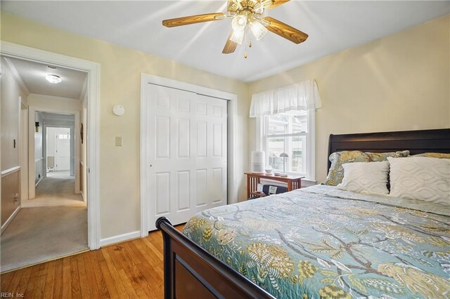 bedroom with a closet, baseboards, ceiling fan, and hardwood / wood-style floors