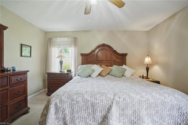bedroom with light colored carpet, a ceiling fan, and baseboards