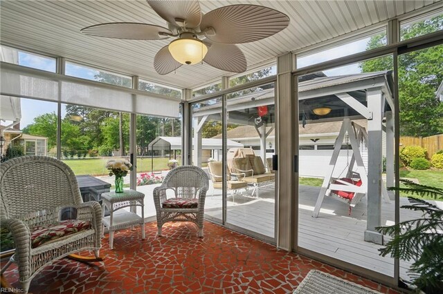 sunroom featuring ceiling fan and a healthy amount of sunlight
