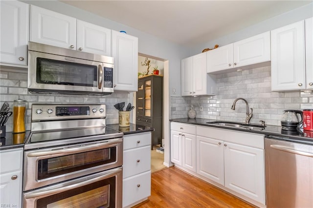 1628 Red Brook Ct, Norfolk, VA 23518 - kitchen with stainless steel appliances, a sink, dark countertops, tasteful backsplash, and white cabinetry