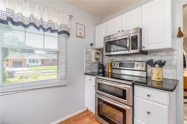 kitchen with backsplash, stainless steel appliances, dark countertops, and white cabinets