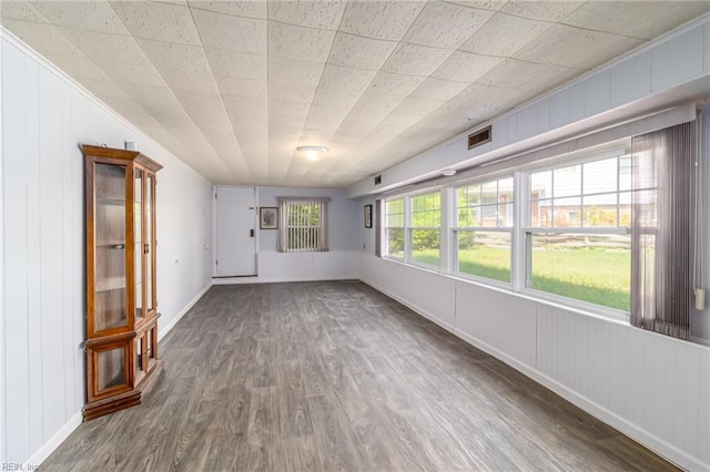 unfurnished living room with baseboards, wood finished floors, and visible vents