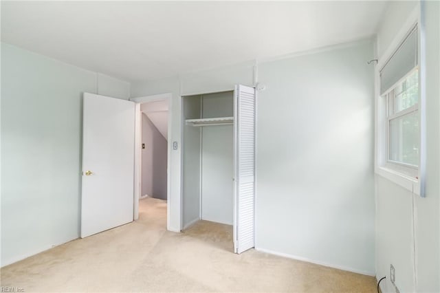 unfurnished bedroom with a closet and light carpet