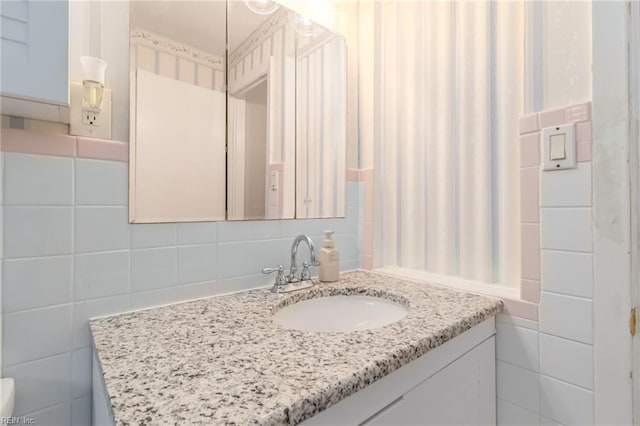 bathroom featuring vanity and tile walls