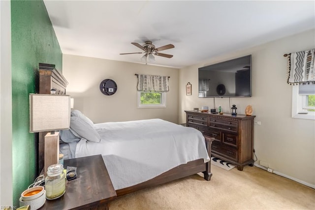 bedroom with baseboards, ceiling fan, and light carpet