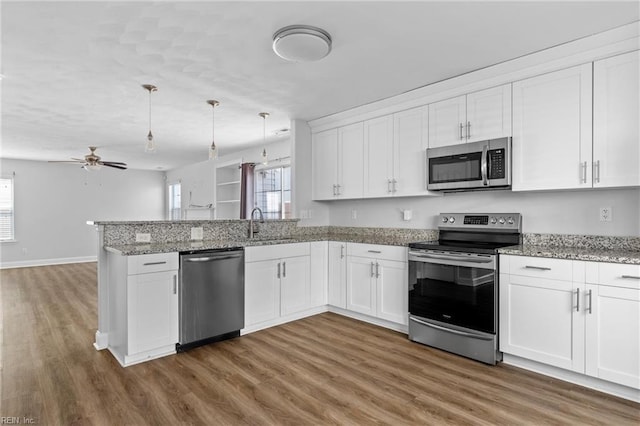 159 Stoney Ridge Ave, Suffolk, VA 23435 - kitchen with stainless steel appliances, white cabinetry, a peninsula, wood finished floors, and a wealth of natural light