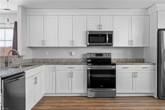 159 Stoney Ridge Ave, Suffolk, VA 23435 - kitchen with white cabinets, light stone countertops, a sink, stainless steel appliances, and visible vents