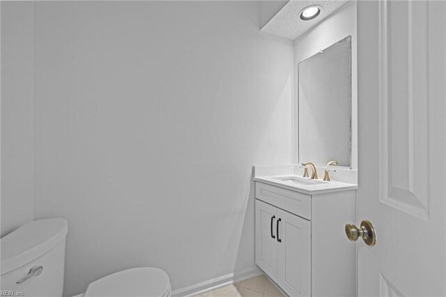 bathroom featuring toilet, tile patterned flooring, and vanity