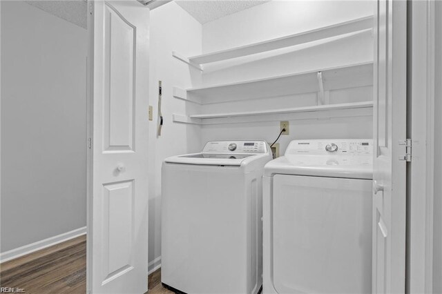 laundry area featuring laundry area, baseboards, dark wood-style floors, washer and clothes dryer, and a textured ceiling