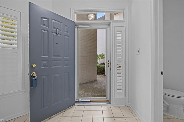 entrance foyer with baseboards, light tile patterned floors, and a wealth of natural light