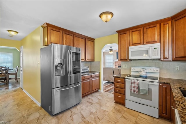 kitchen with white appliances, brown cabinets, and decorative backsplash