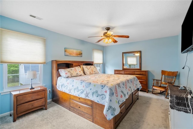 bedroom featuring baseboards, multiple windows, light carpet, and visible vents