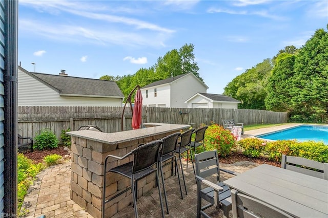 view of patio featuring a fenced in pool, a fenced backyard, and outdoor dry bar
