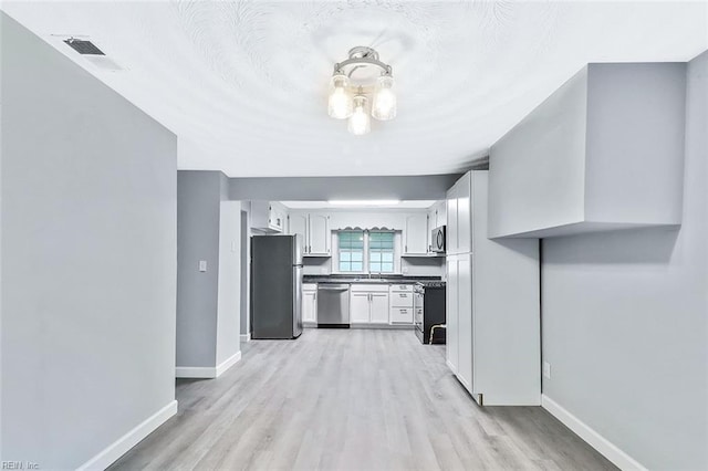 913 Garfield Ave, Suffolk, VA 23434 - kitchen featuring visible vents, baseboards, light wood-style floors, white cabinetry, and appliances with stainless steel finishes