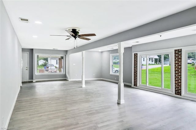 913 Garfield Ave, Suffolk, VA 23434 - unfurnished living room featuring a ceiling fan, visible vents, wood finished floors, baseboards, and ornate columns