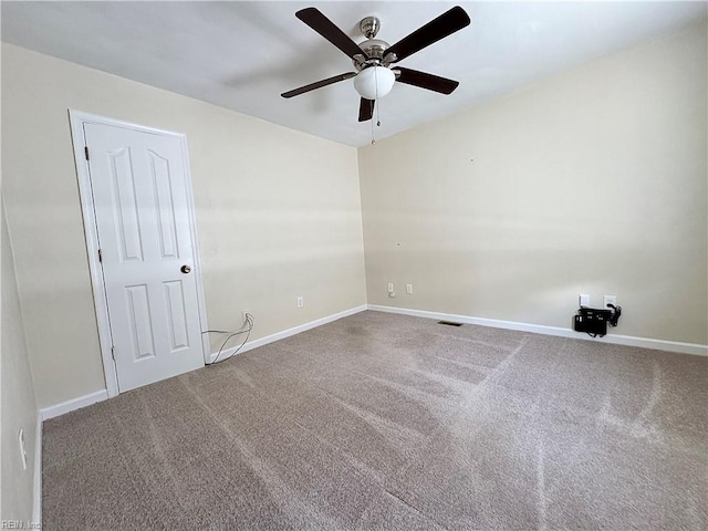 carpeted spare room with a ceiling fan and baseboards