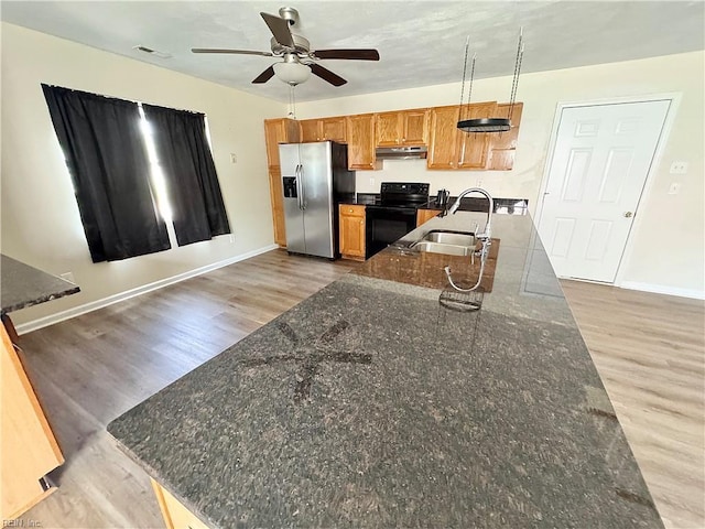 kitchen featuring a ceiling fan, black electric range, a sink, stainless steel fridge with ice dispenser, and under cabinet range hood