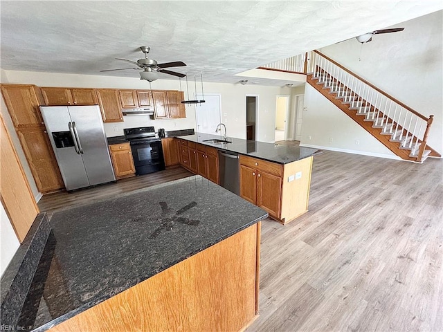 kitchen featuring ceiling fan, a sink, stainless steel appliances, a peninsula, and under cabinet range hood