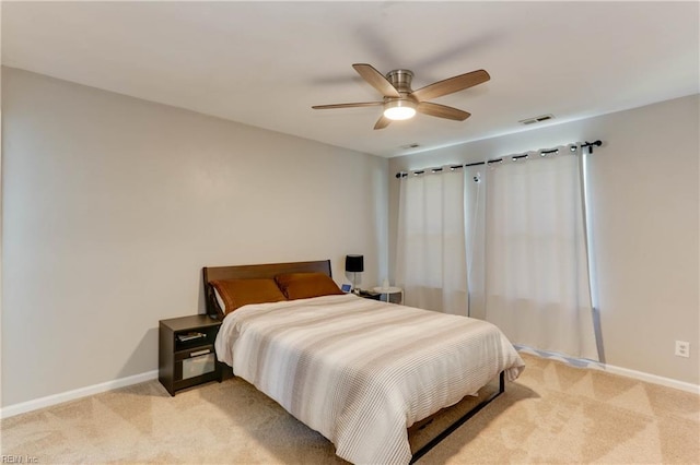 bedroom with visible vents, baseboards, and light carpet