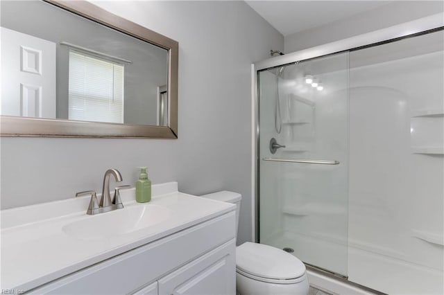 bathroom with vanity, toilet, and a stall shower