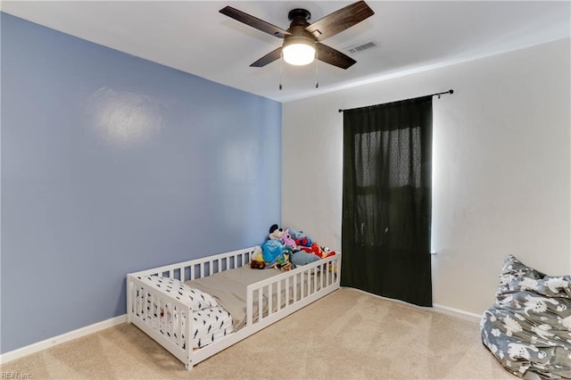 carpeted bedroom featuring baseboards, ceiling fan, and visible vents