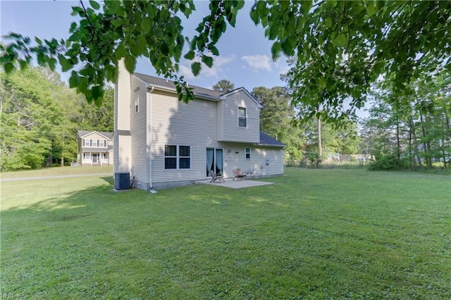 rear view of property featuring a lawn, central AC unit, a chimney, and a patio