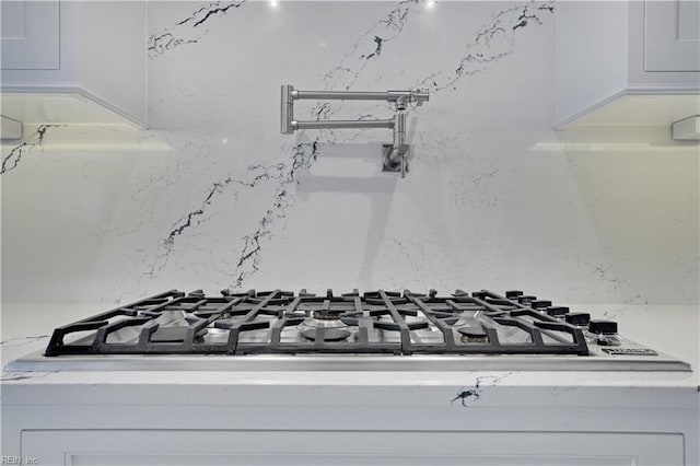 interior details featuring white cabinets and stainless steel gas stovetop