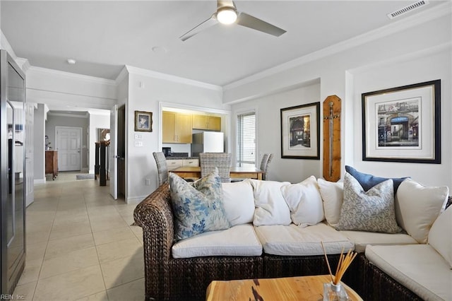 living room featuring crown molding, a ceiling fan, baseboards, light tile patterned floors, and visible vents