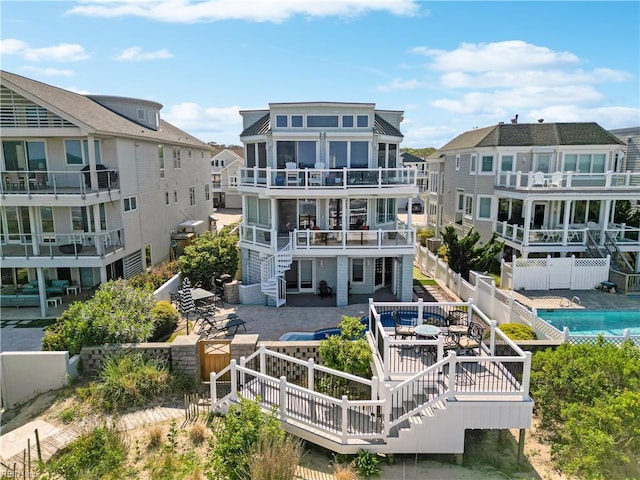 back of property featuring a patio, a fenced backyard, stairs, a fenced in pool, and a residential view