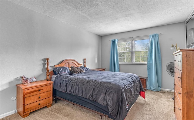 bedroom featuring baseboards, light carpet, and a textured ceiling
