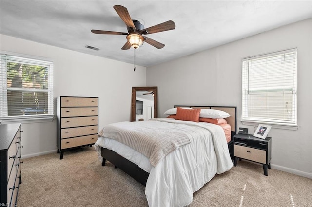 bedroom featuring baseboards, visible vents, and light carpet
