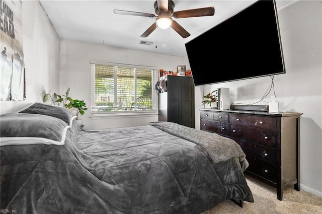 bedroom featuring visible vents, a ceiling fan, baseboards, and light colored carpet