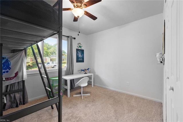 office space featuring baseboards, a ceiling fan, and carpet