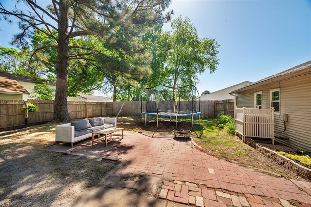 view of patio featuring a fenced backyard, a trampoline, and outdoor lounge area