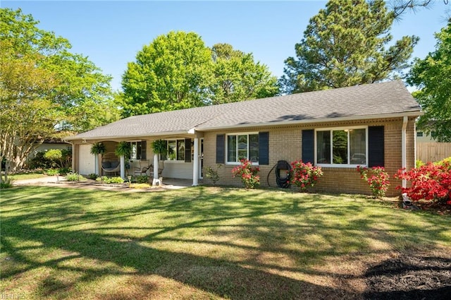 single story home featuring a shingled roof, an attached garage, a front lawn, and brick siding