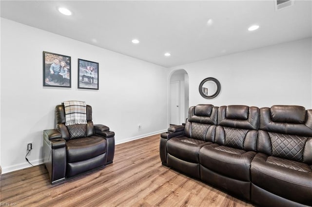 living area featuring visible vents, arched walkways, light wood-style floors, and recessed lighting