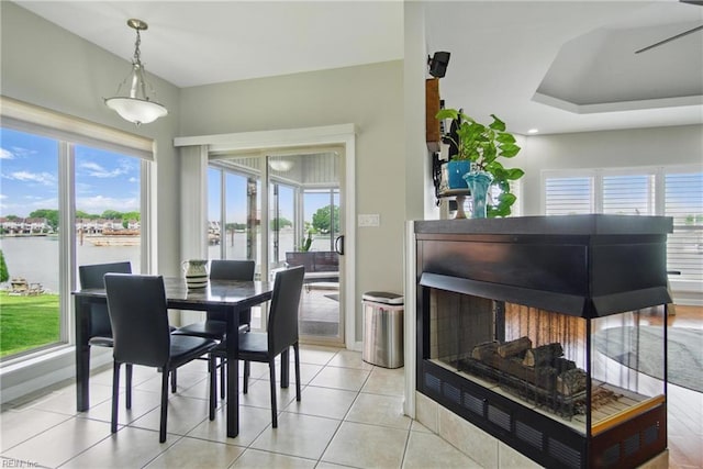 dining room featuring light tile patterned floors and a water view
